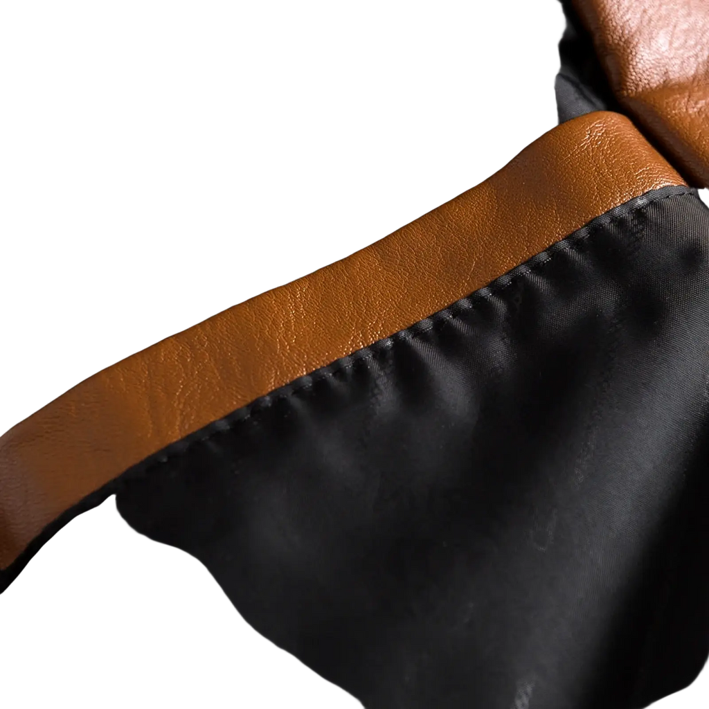 A men faux leather double-breasted blazer with tan leather trim accenting the black satin lining