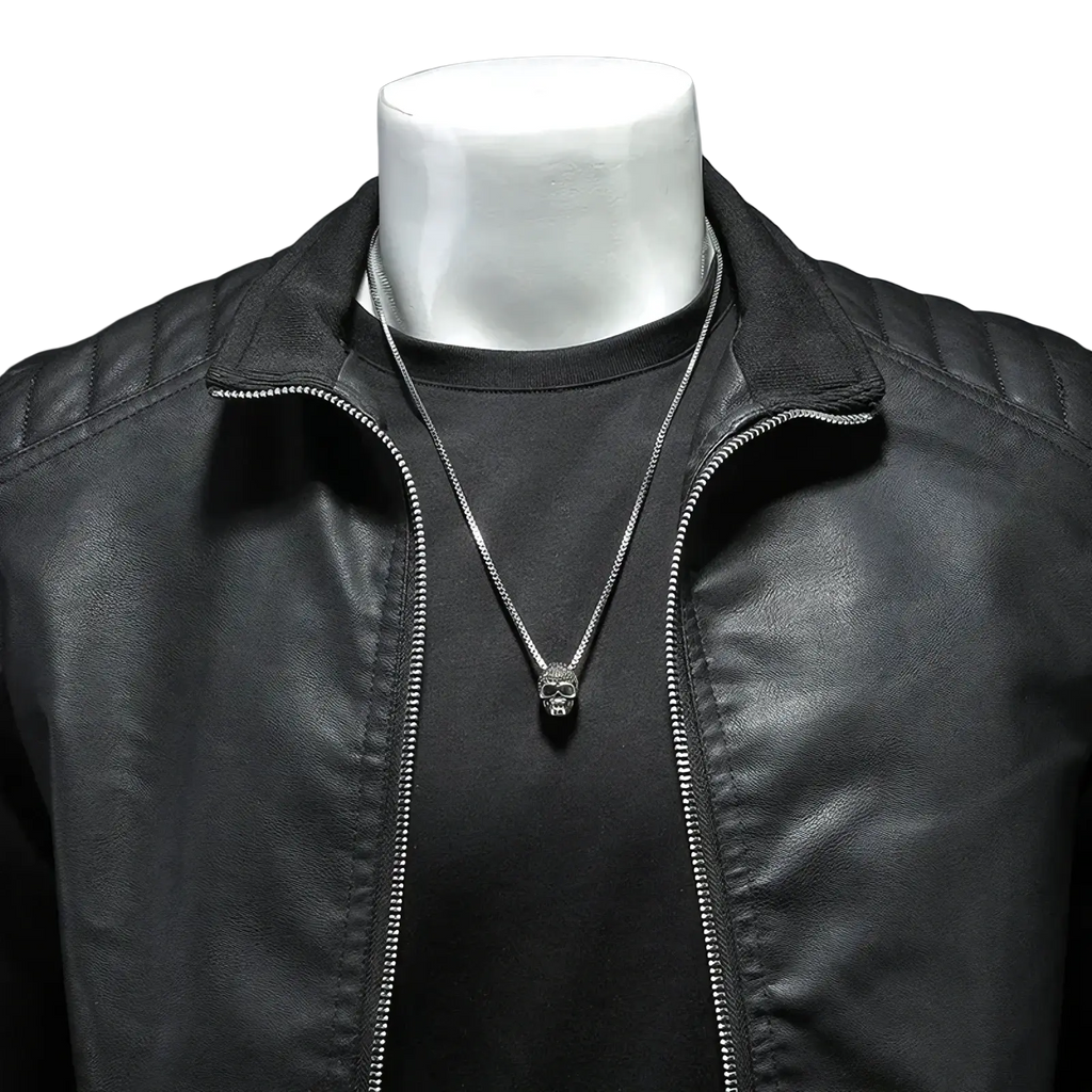 Silver skull pendant necklace with sleek chain displayed on black faux leather men motorcycle jacket biker outerwear