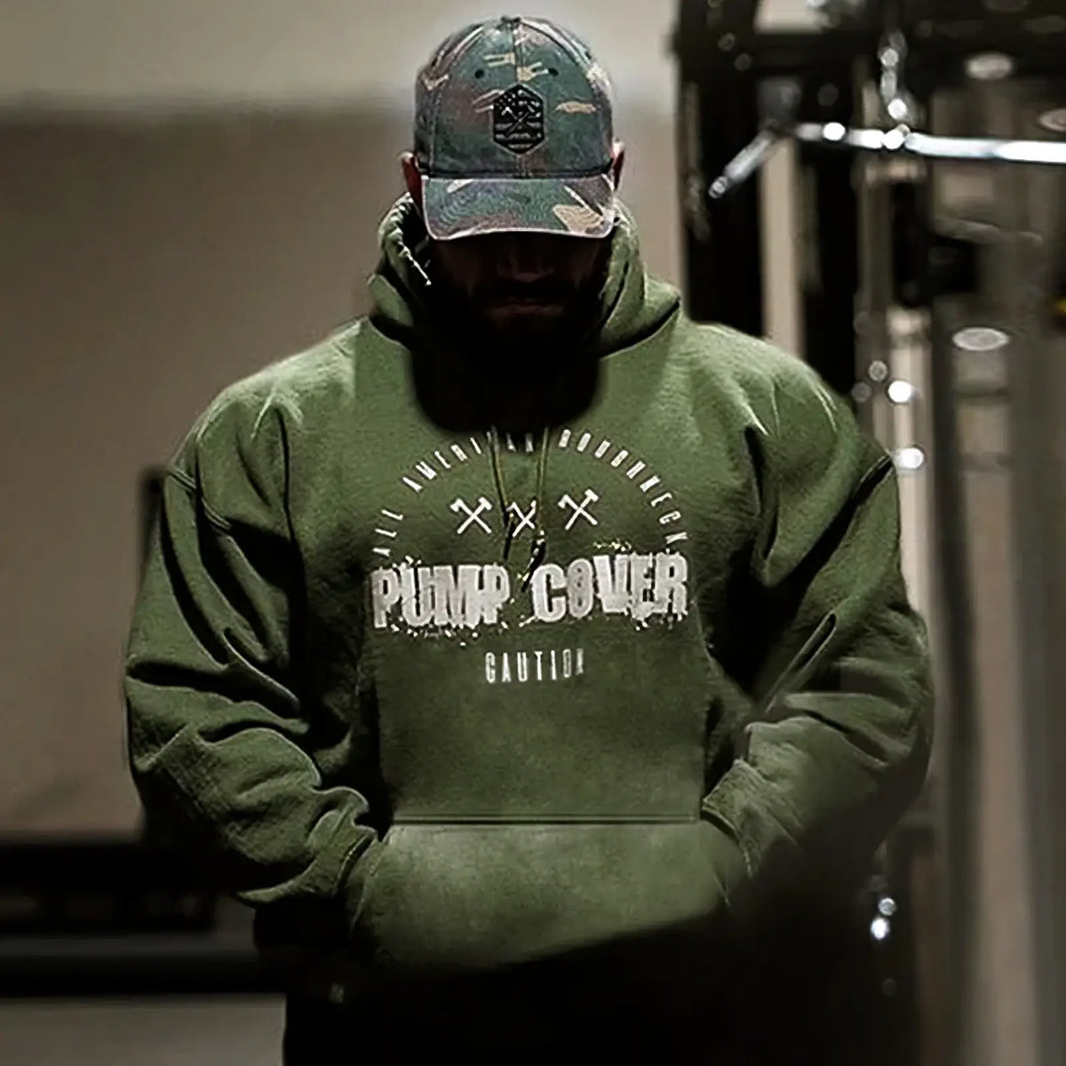 Men fleece gym hoodie pullover in olive green with distressed white pump cover graphic and crossed hammer design worn with cap