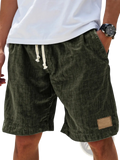 Men linen holiday shorts in olive green corduroy with white drawstrings and a tan leather patch on the side seam