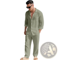 A man wearing a light green linen long sleeve shirt and pants set standing on a sandy beach