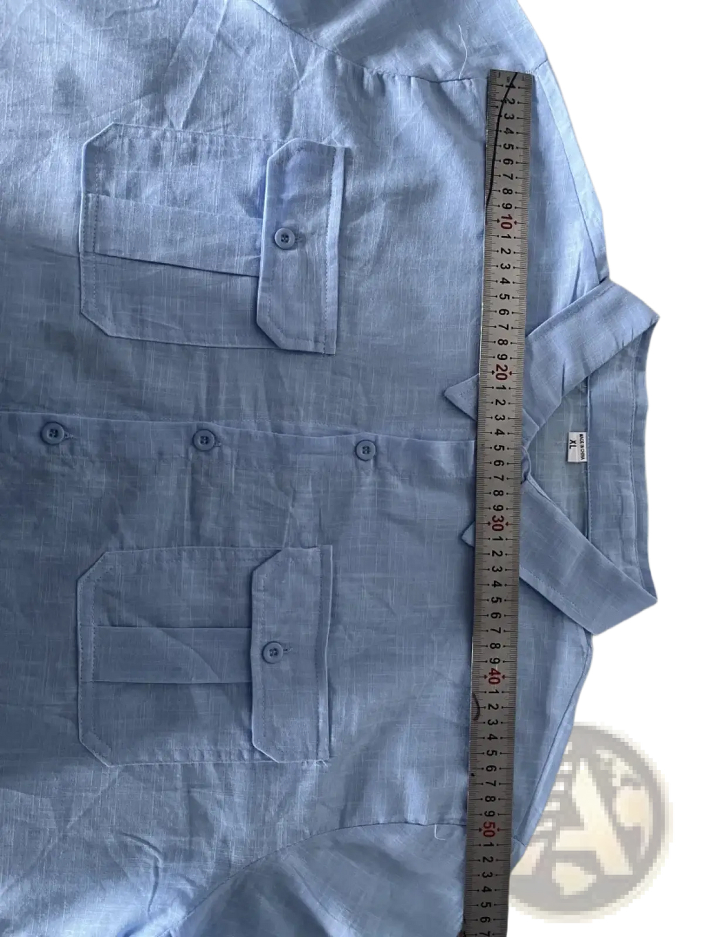 Light blue linen short sleeve button-up shirt with collar and two chest pockets for casual summer wear