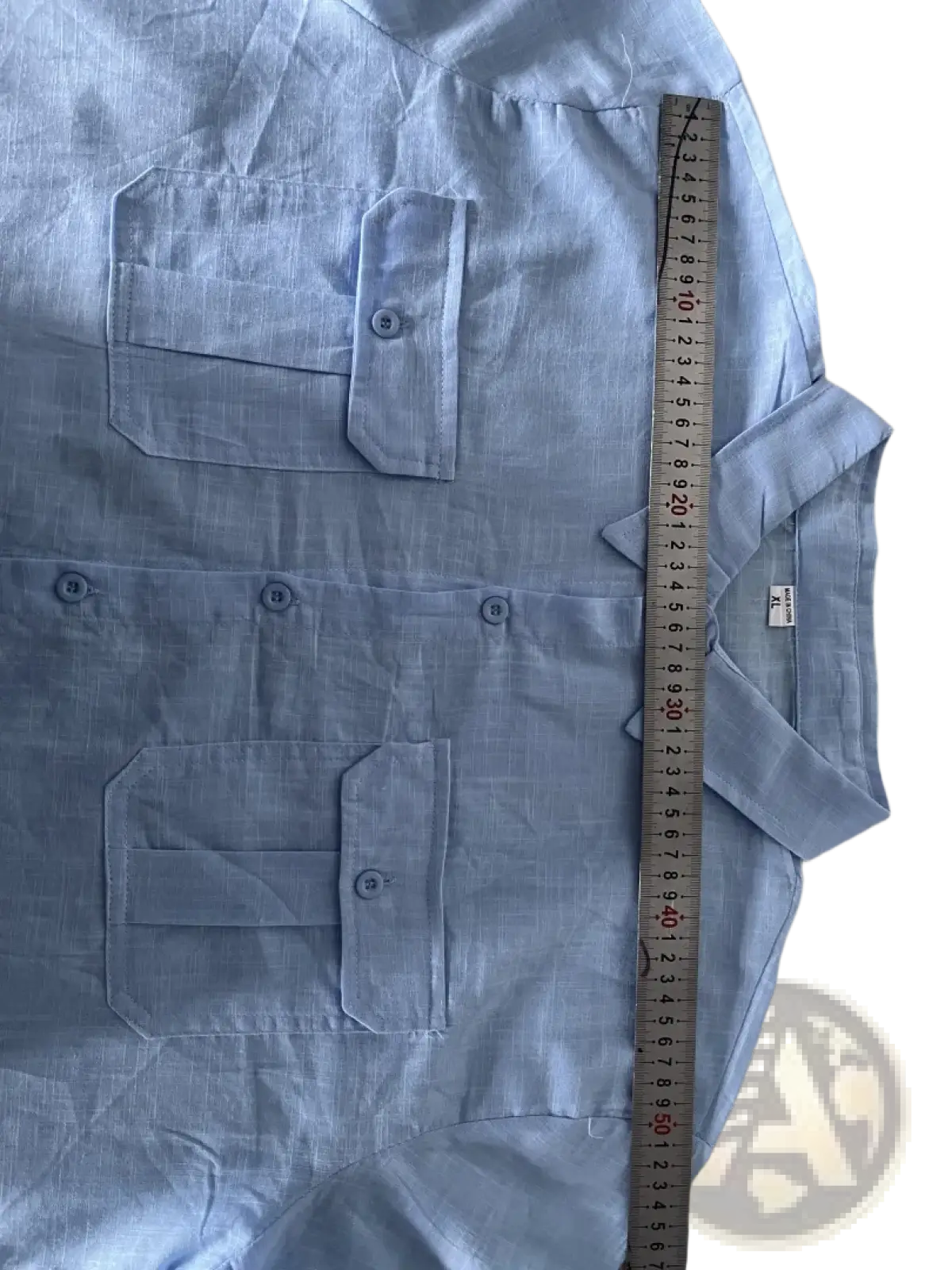 Light blue linen short sleeve button-up shirt with collar and two chest pockets for casual summer wear