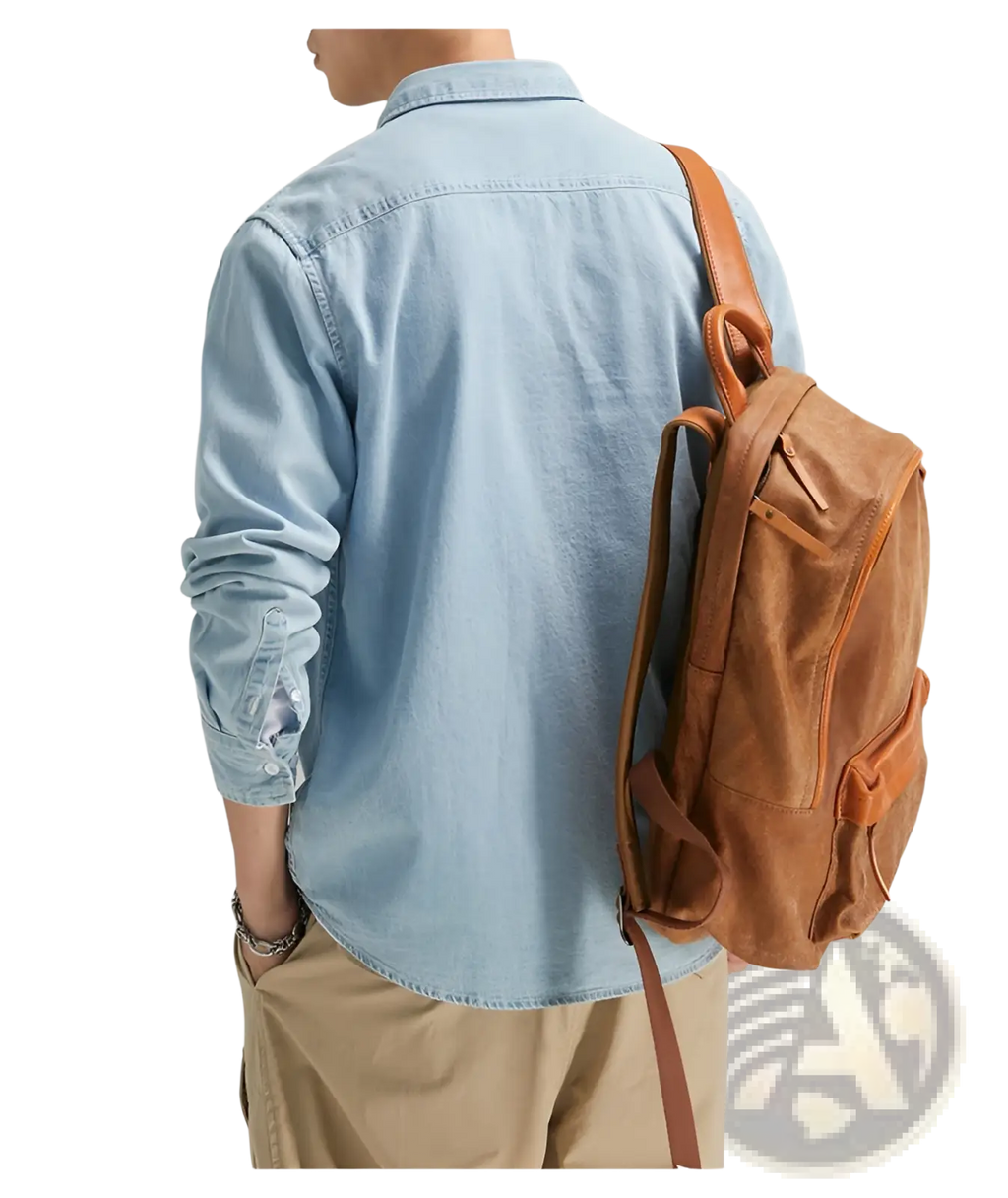 Tan leather backpack with brown straps and visible stitching details paired with men long sleeve denim shirt casual button up