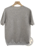 A soft heather gray men merino wool short sleeve sweater with ribbed crew neckline and cuffs