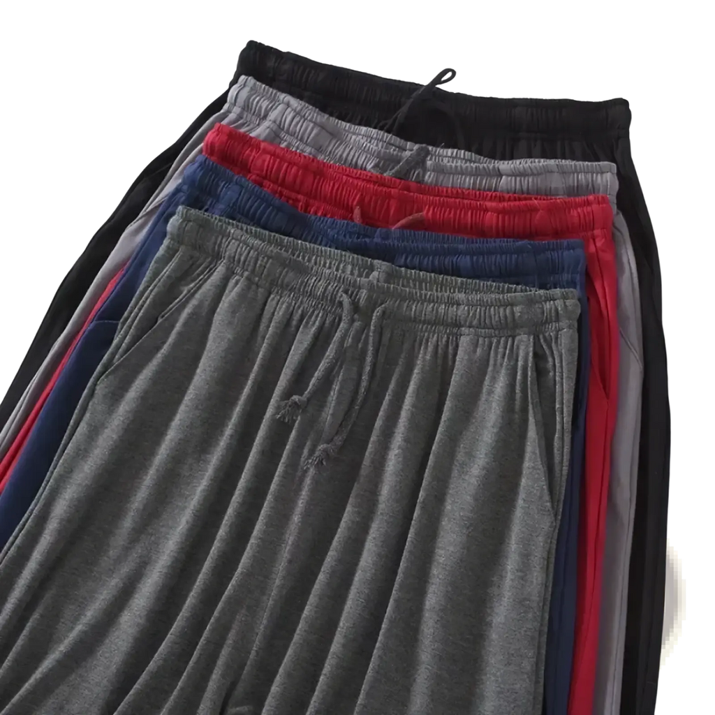 A stack of men modal cotton lounge shorts in black gray red and navy blue with elastic waistbands and drawstrings