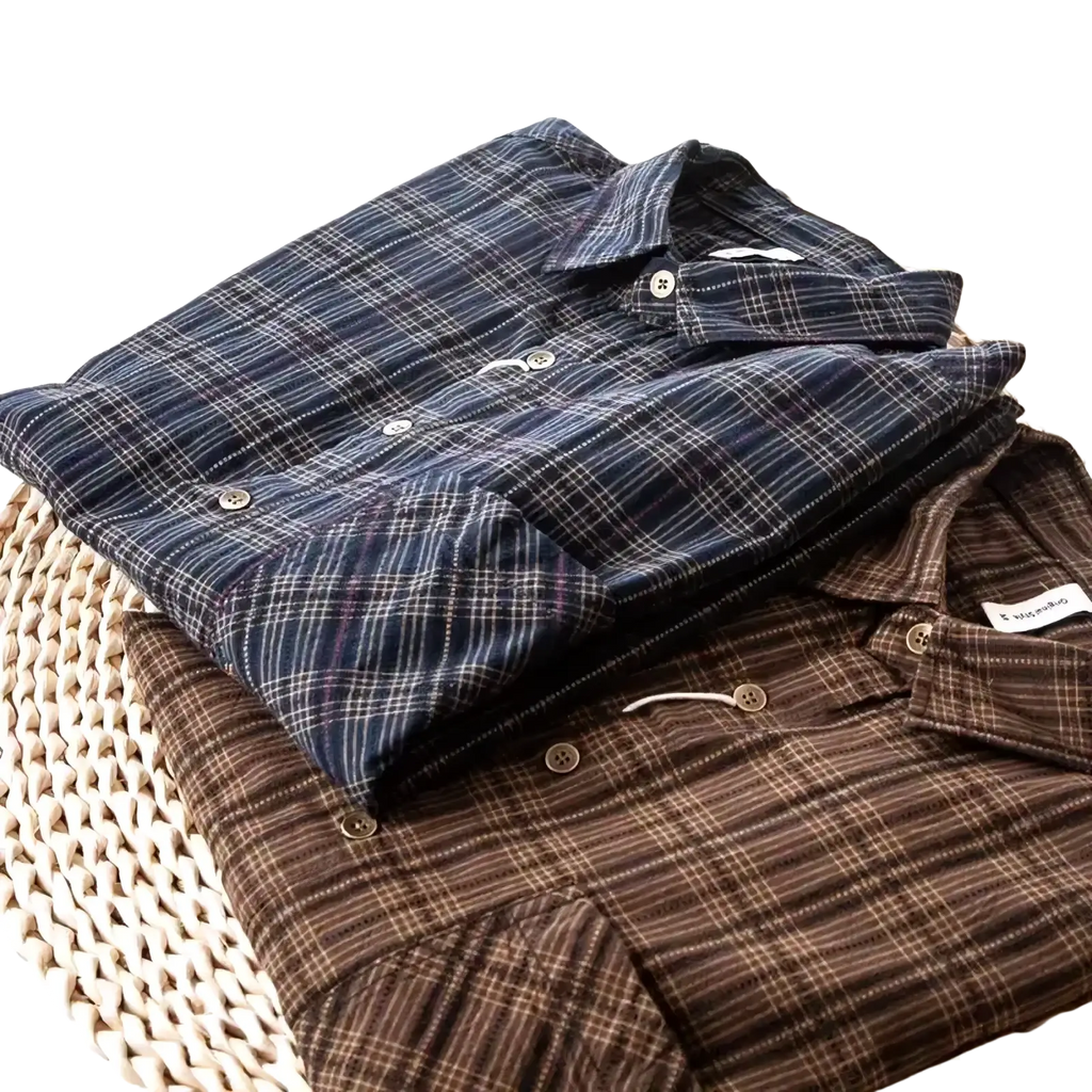 Men plaid embroidered cotton shirts in dark navy white and brown beige stacked neatly on woven basket