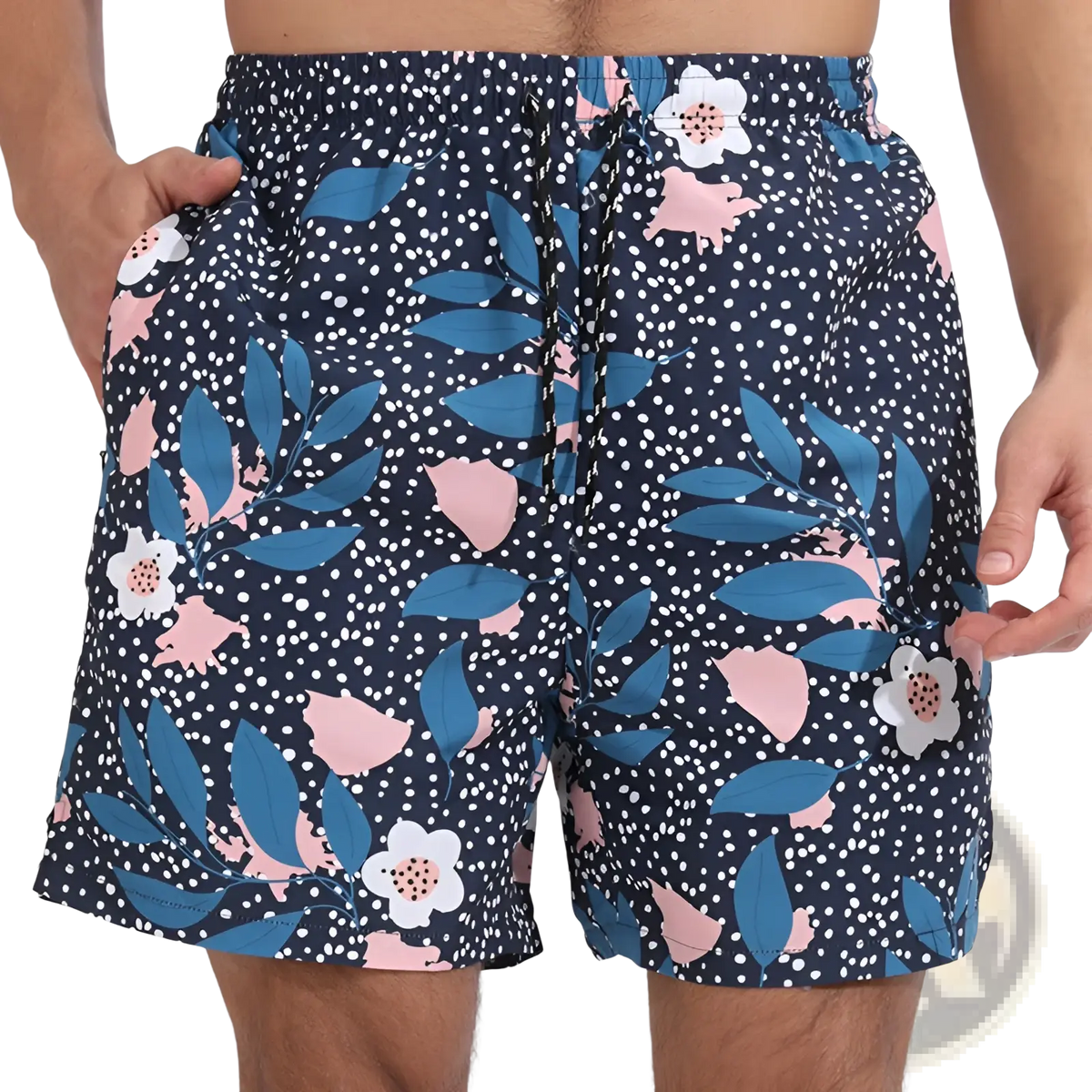 Men printed swim trunks in navy blue with a floral pattern featuring white flowers pink blossoms and teal leaves on a dotted background