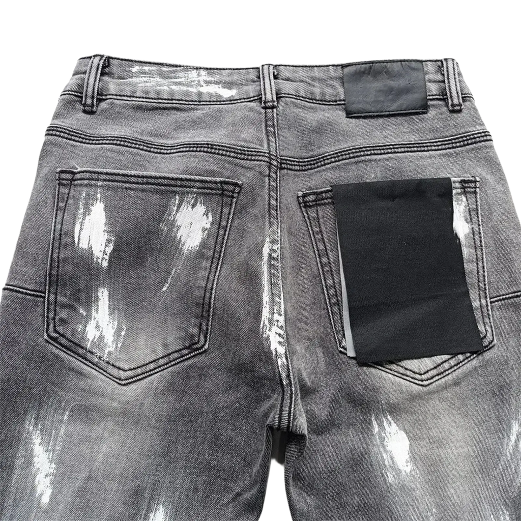 Back side of men ripped skinny jeans in gray distressed denim with white paint splatter and black pocket patches