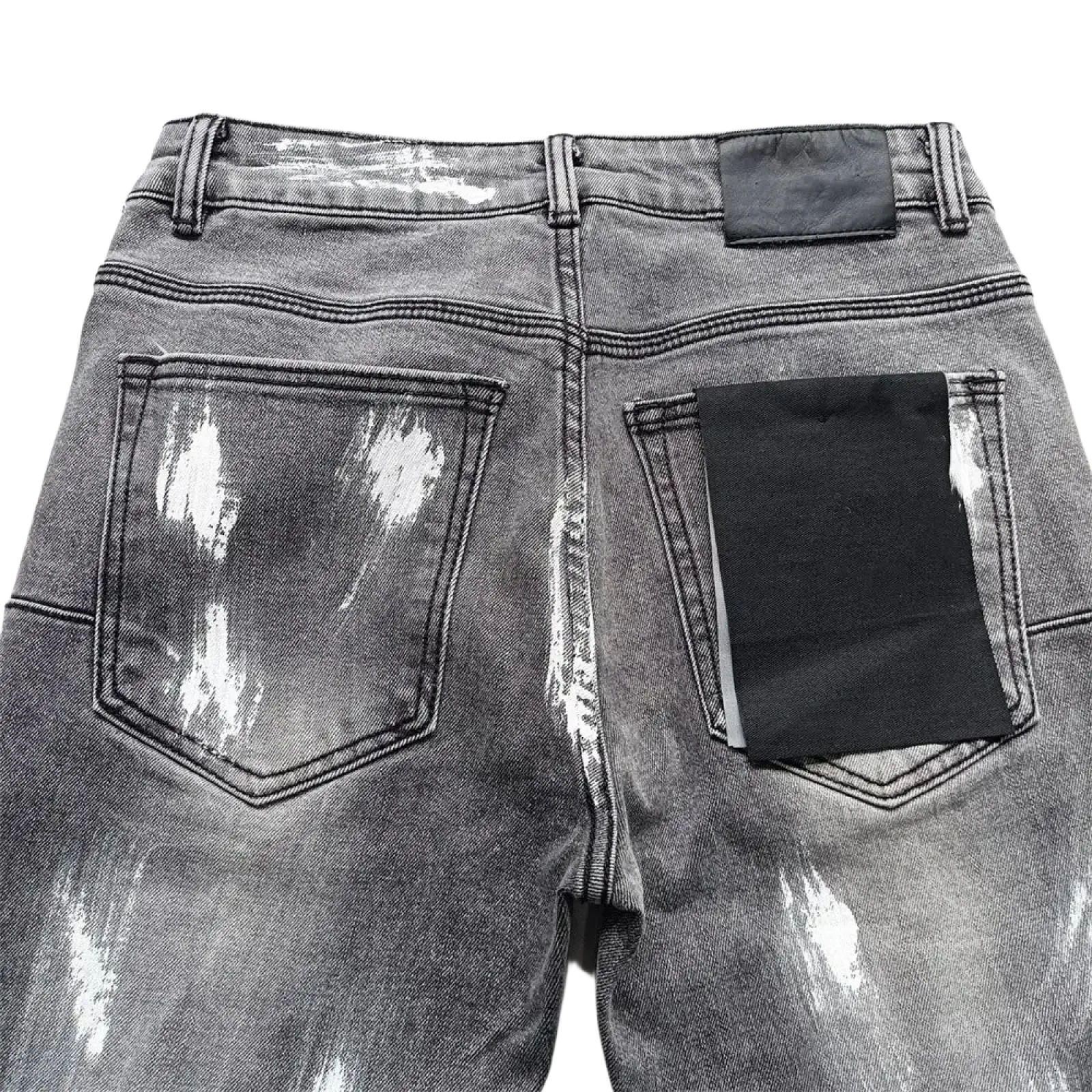 Back side of men ripped skinny jeans in gray distressed denim with white paint splatter and black pocket patches