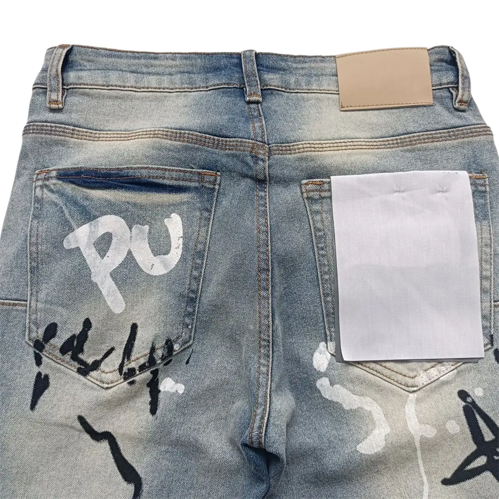 Back view of men ripped skinny jeans in light-wash denim with graffiti-style white and black spray paint on back pockets