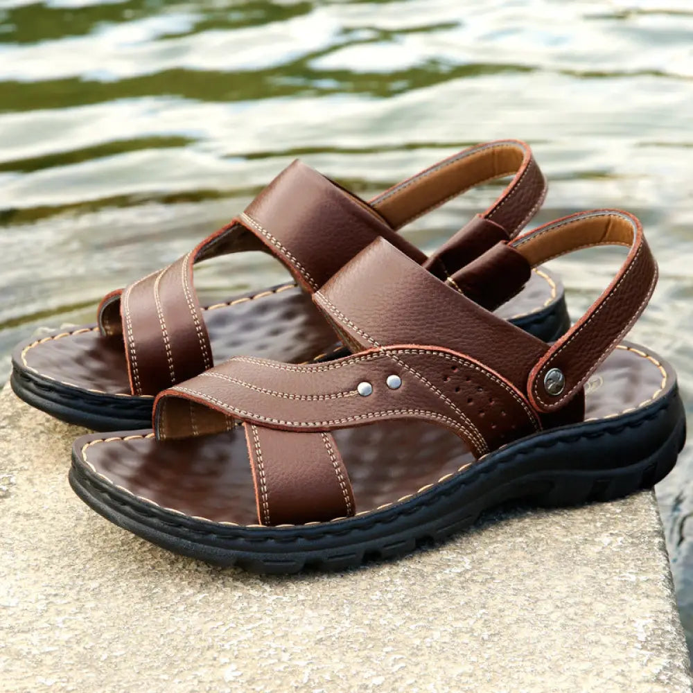 Men’s adjustable genuine leather brown sandals with sturdy black rubber sole and decorative stitching for summer beach use