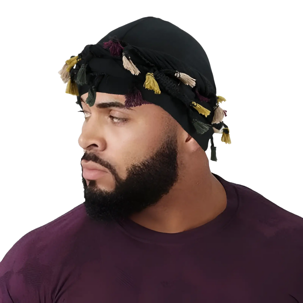 Men satin lined beard twist cap in black fabric adorned with colorful yellow beige and purple tassels shown from back side