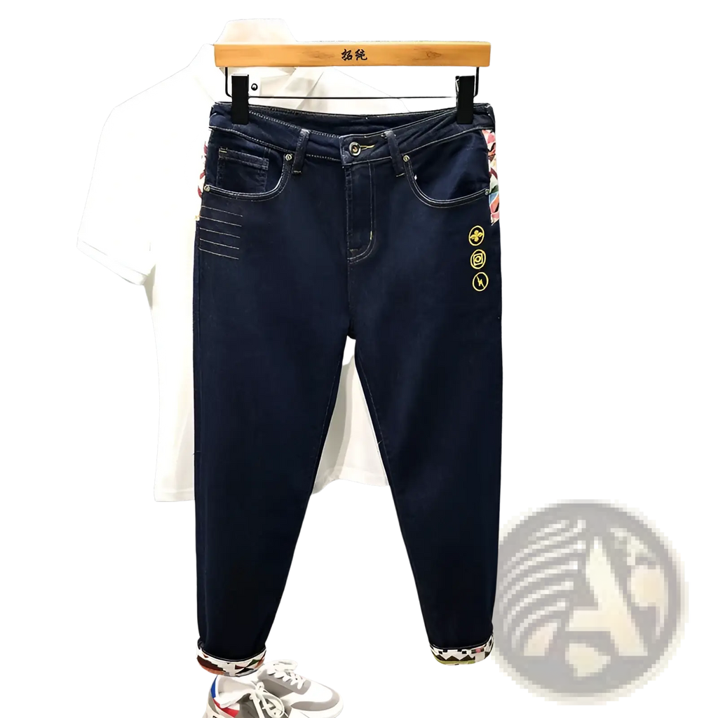 Men slim fit stretch white denim jeans with dark blue embroidered circular motifs and patterned cuffs on wooden hanger
