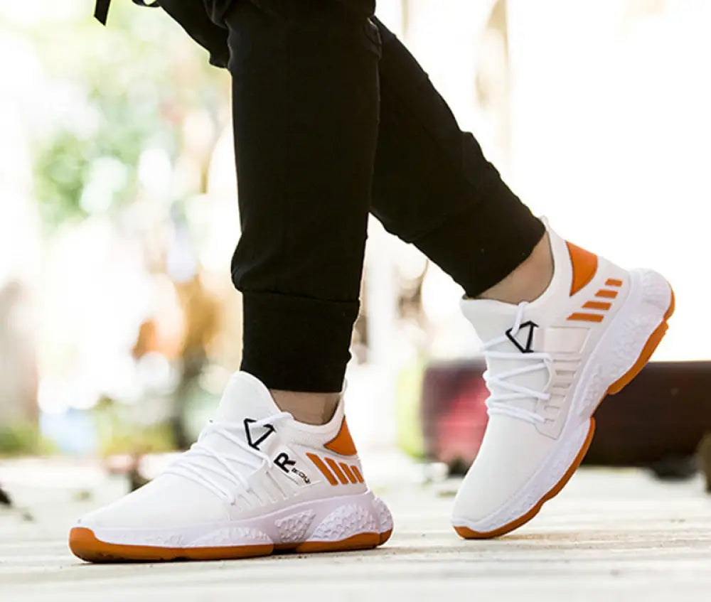 Men’s breathable mesh athletic sports sneakers in white and orange with sleek design and bold accent stripes