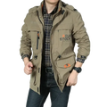 Men tactical waterproof outdoor jacket in khaki olive green with multiple pockets and orange zipper pulls featuring roug stock logo