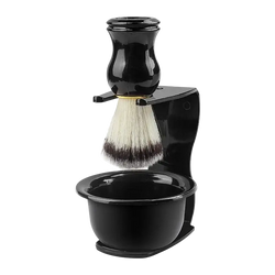 Black shaving brush with white and dark bristles mounted on black stand with integrated shaving bowl for wet shaving kit