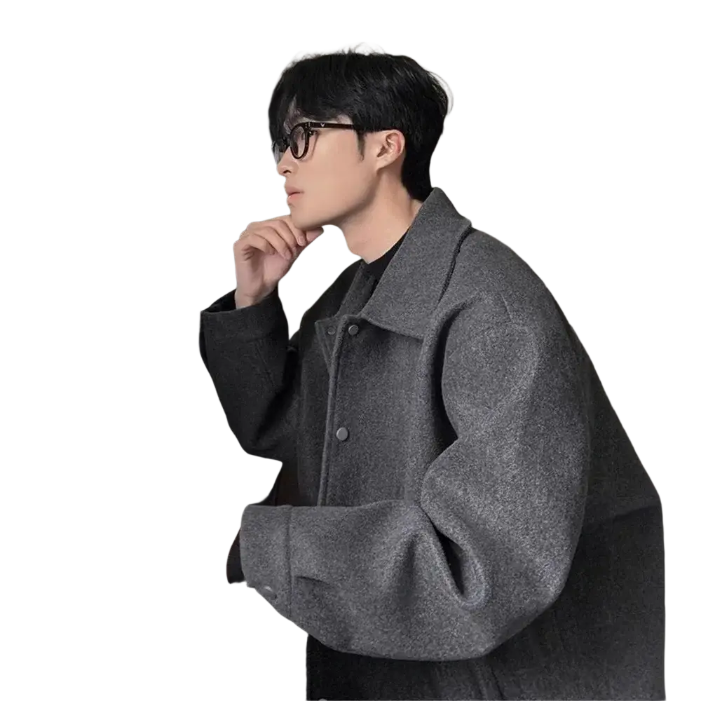 A gray wool mid length men’s coat with textured fabric, classic collar, and button closure for warm winter wear