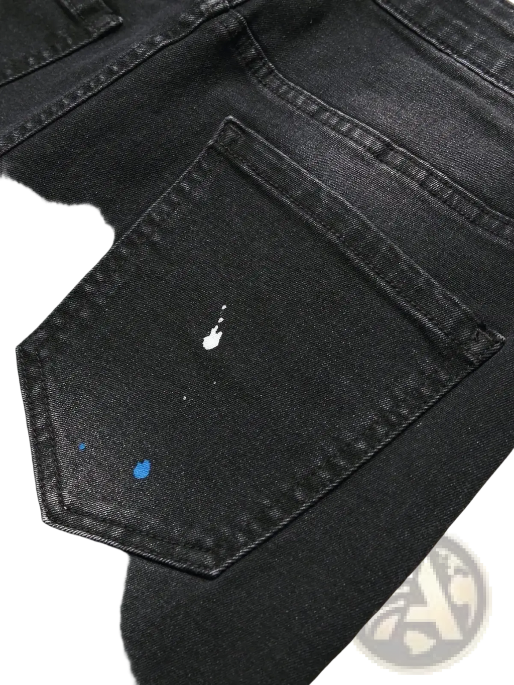 Men y2k stretchy skinny ripped denim jeans in black featuring a distressed back pocket with white and blue paint splatters