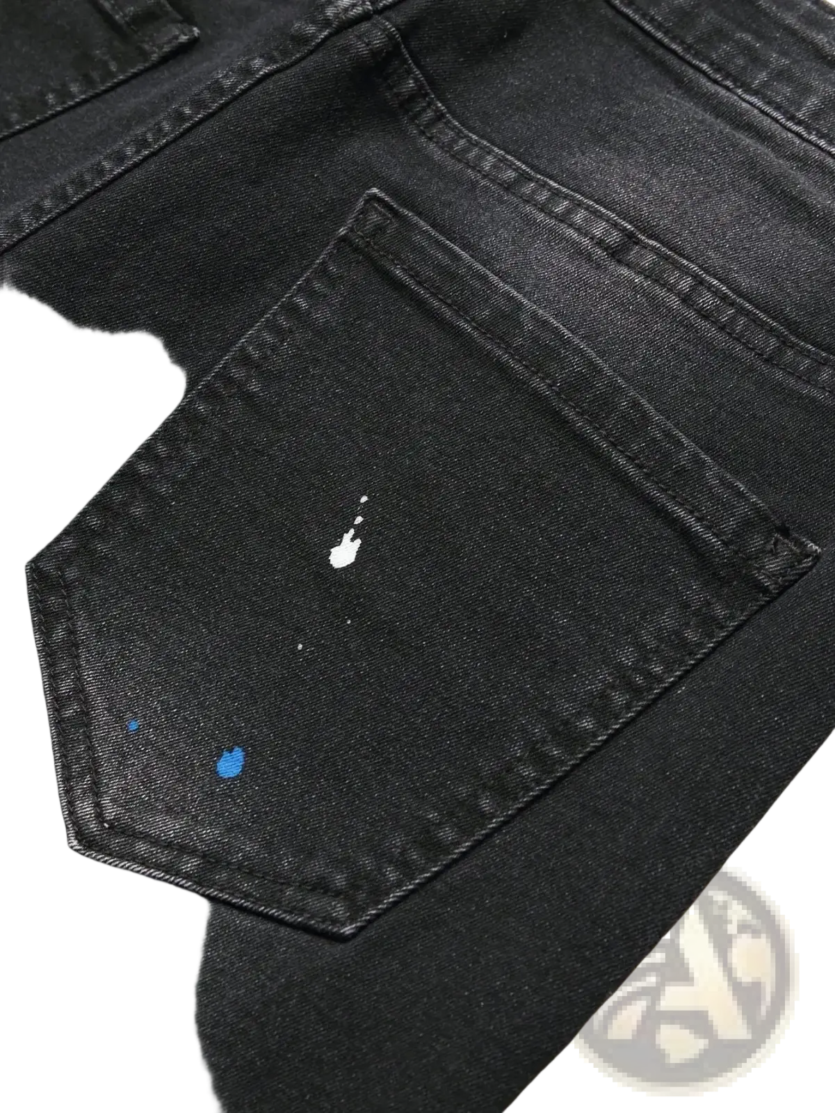 Men y2k stretchy skinny ripped denim jeans in black featuring a distressed back pocket with white and blue paint splatters