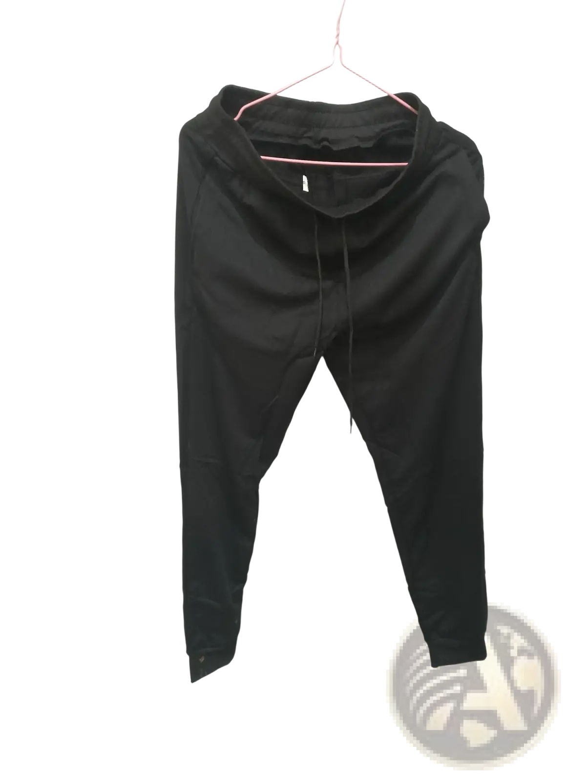Men’s black athletic training jogger pants with drawstring waistband and tapered legs hanging on pink hanger