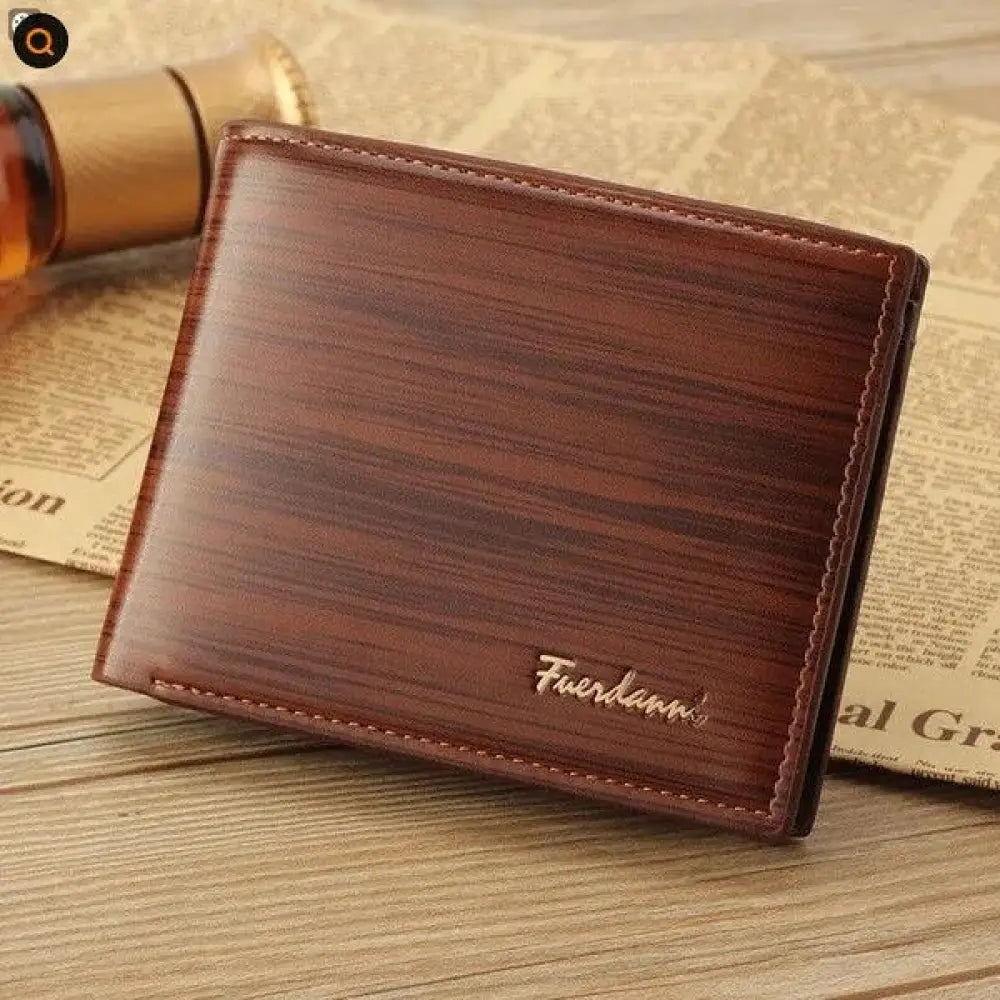 Brown leather bifold card wallet with wood grain texture, stitched edges, and fuerdanni brand embossed in gold lettering