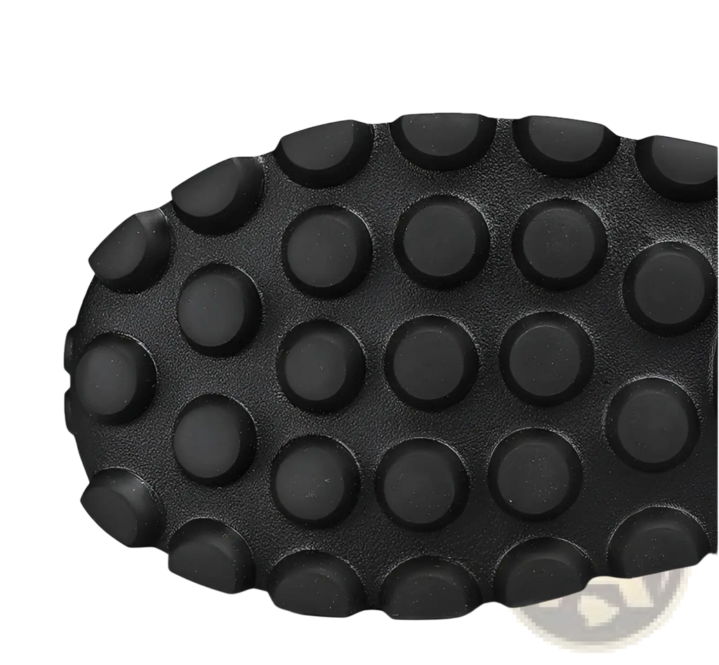 Black rubber sole with a pattern of raised circular studs on men’s black crocodile embossed leather sneakers