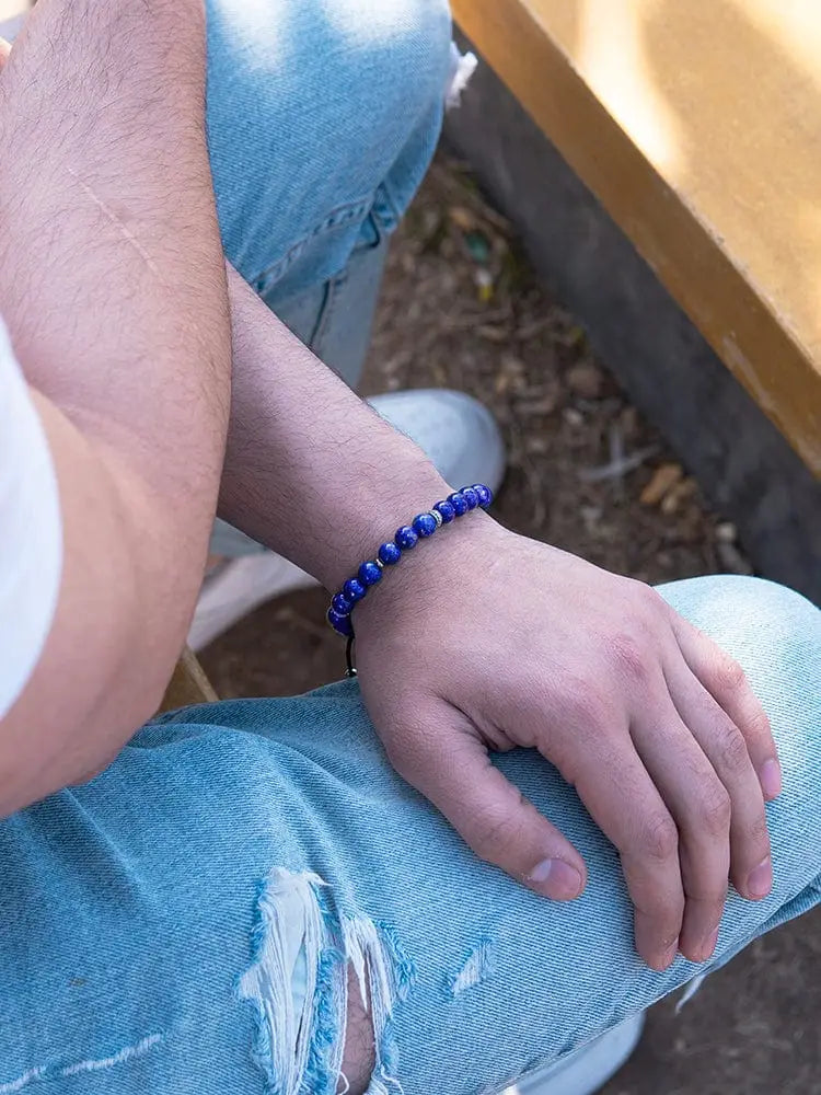 Men’s lapis lazuli beaded bracelet with silver accents in deep blue worn on wrist showing front side