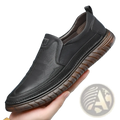 Black leather slip-on men’s breathable non slip PU leather loafers with brown textured rubber sole shown from the back