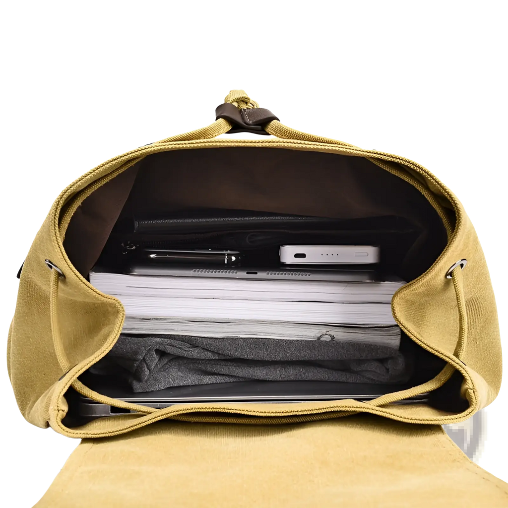 A mustard-yellow men’s canvas travel backpack with brown leather accents and large 20-35l capacity filled with essentials