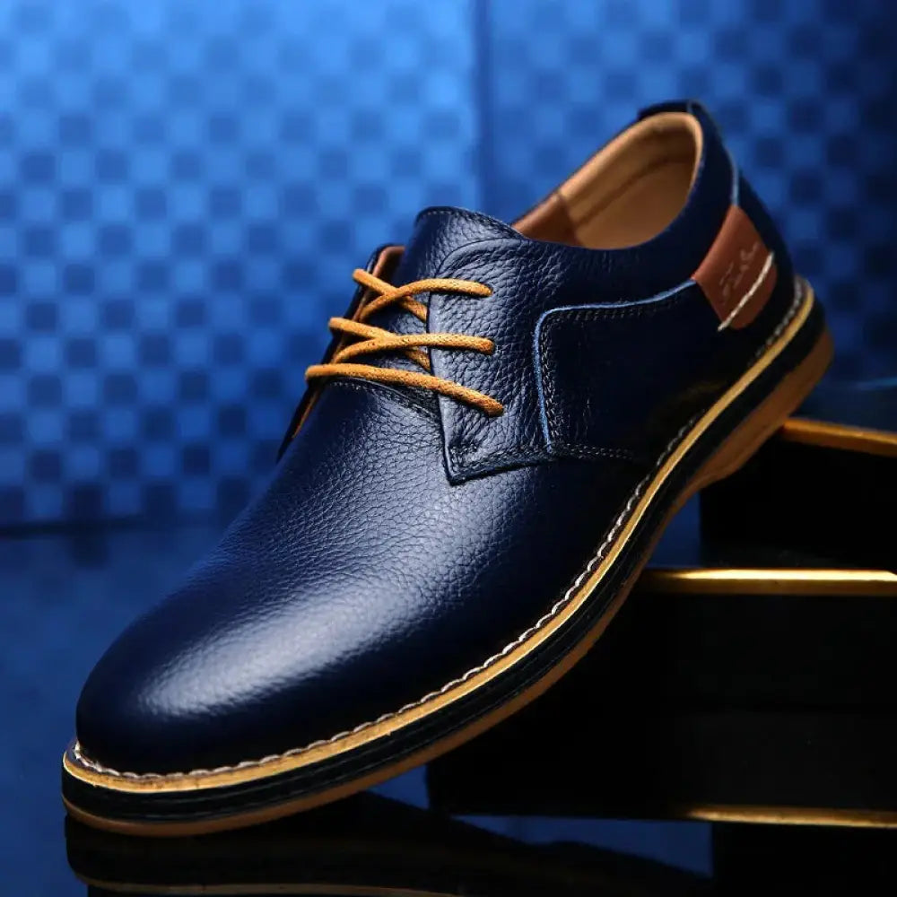 Navy blue leather men’s British lace-up dress shoe with tan laces and detailed tan stitching