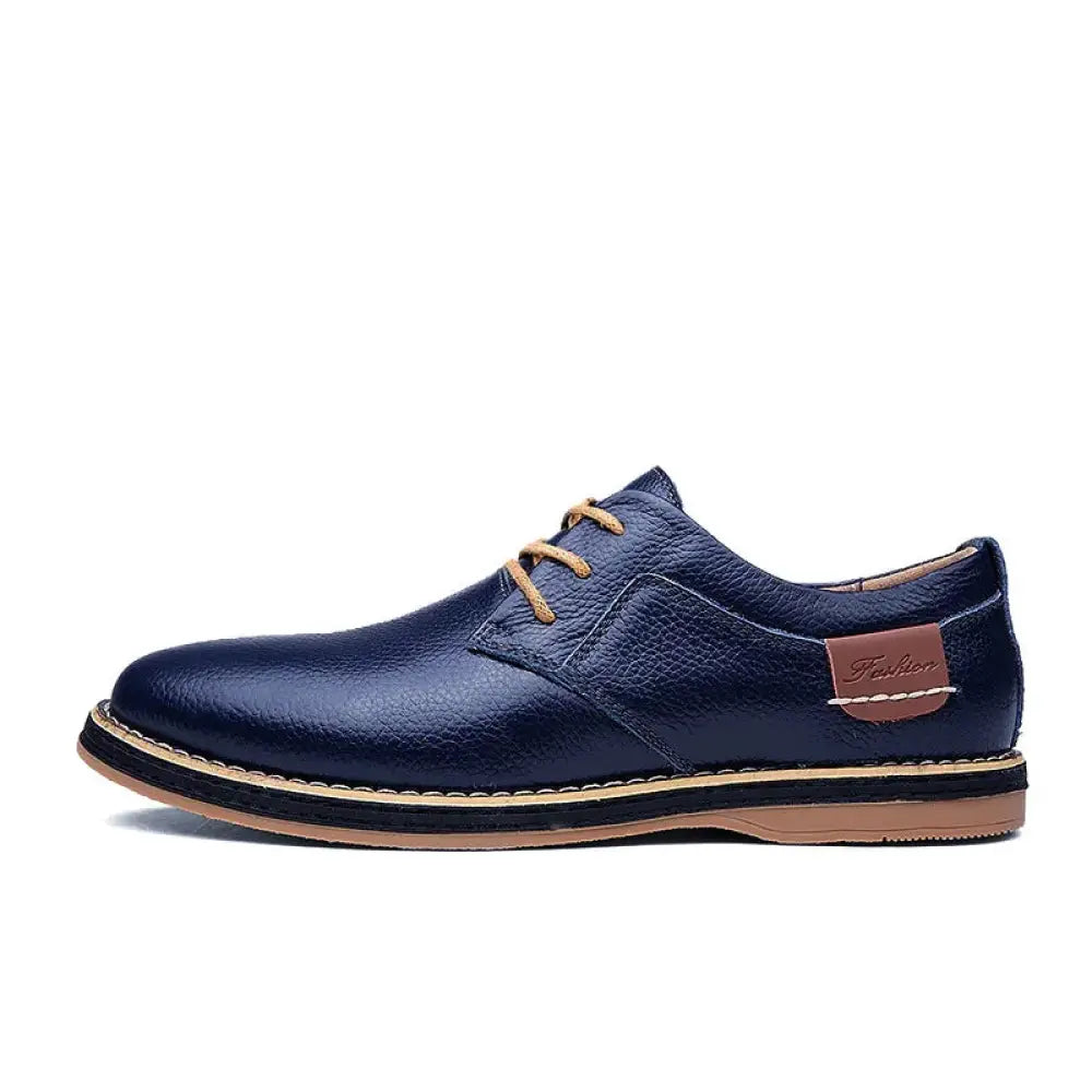 Men’s british leather lace-up dress shoe in navy blue with tan laces and stitching details for formal wear