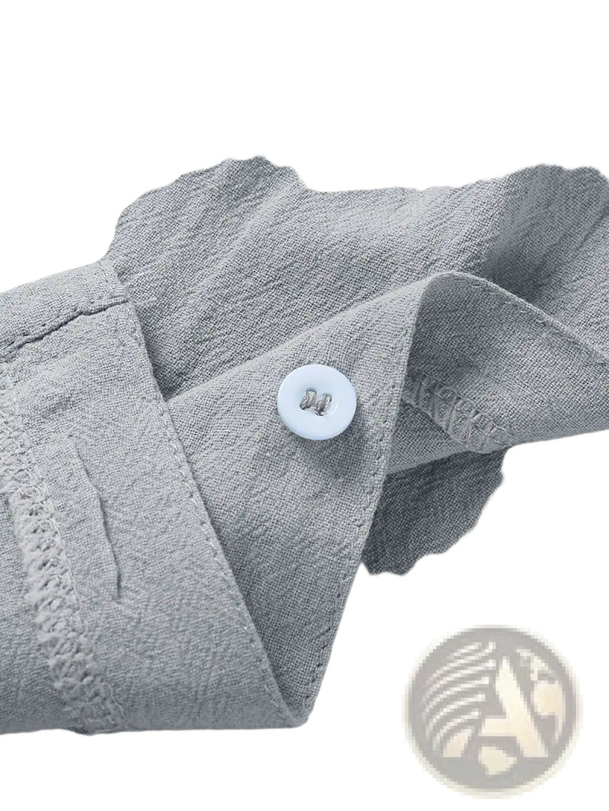 A white round button with a metallic sheen on the gray textured fabric of a men’s casual short sleeve button down shirt