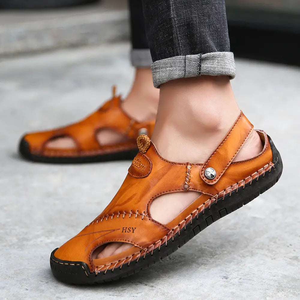 Men’s brown woven leather closed toe beach sandals with tan leather straps black rubber sole and visible stitching details