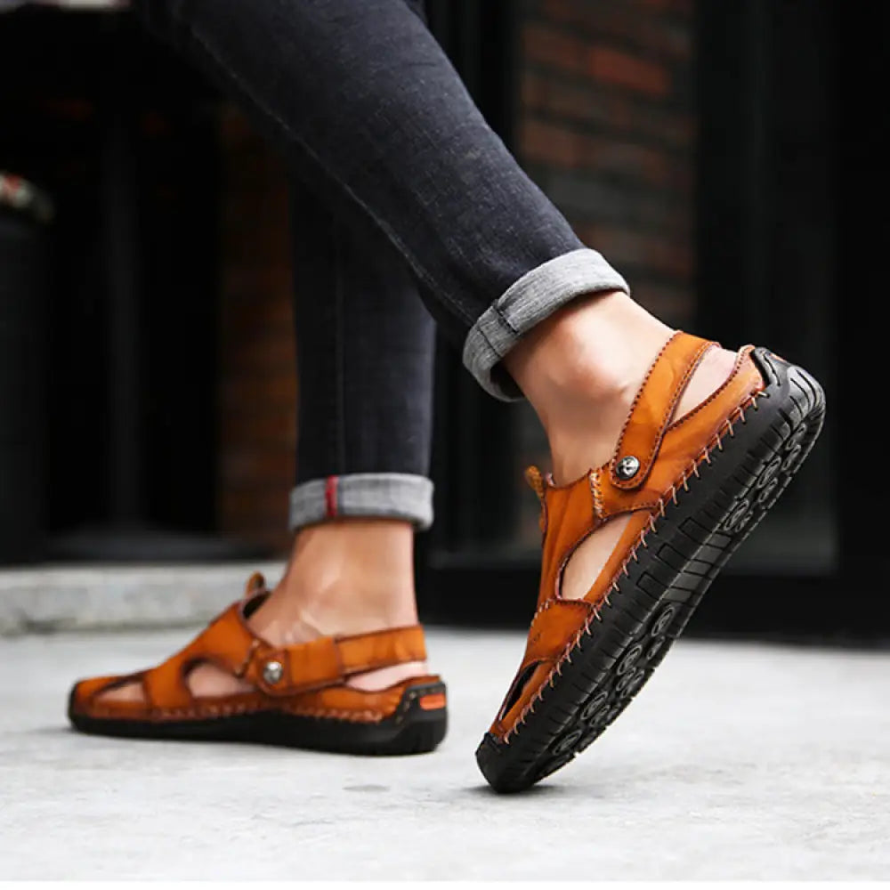 Men’s brown woven leather closed toe beach sandals with tan leather straps black rubber soles and visible stitching details