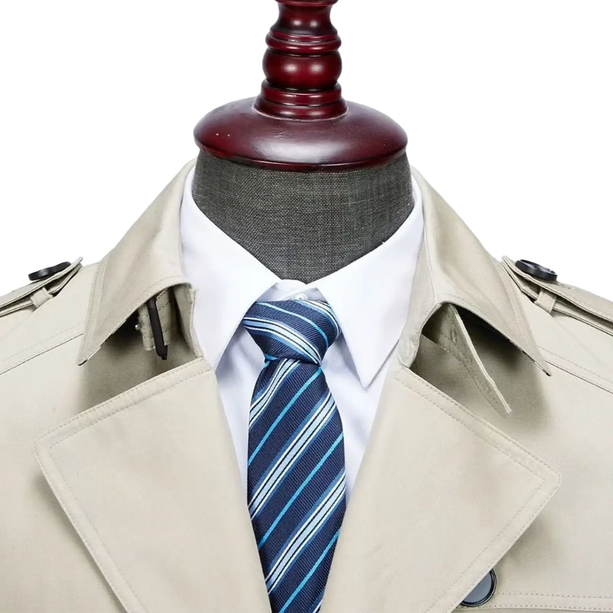 Beige cotton men’s trench coat with classic collar and shoulder straps worn over white shirt with navy blue striped tie