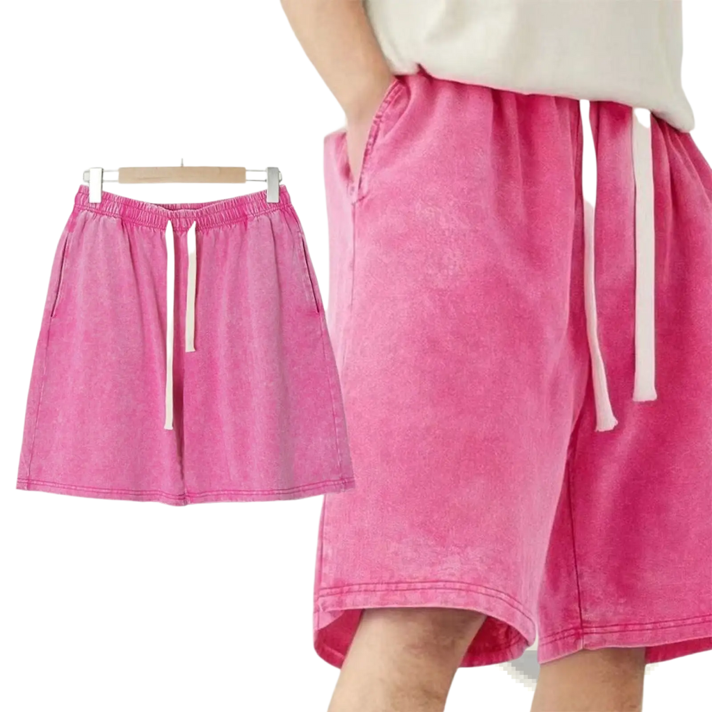 Mens distressed cotton shorts in bright pink featuring a relaxed fit drawstring waist with white cord accents