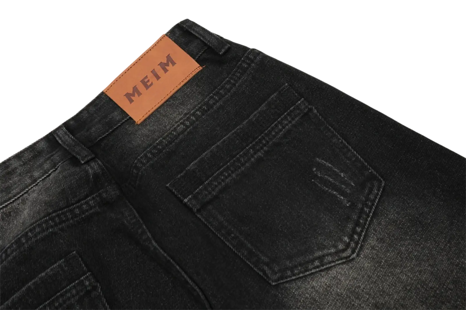 Back side of men’s distressed straight leg black denim jeans featuring a brown leather meim brand patch embossed in black lettering