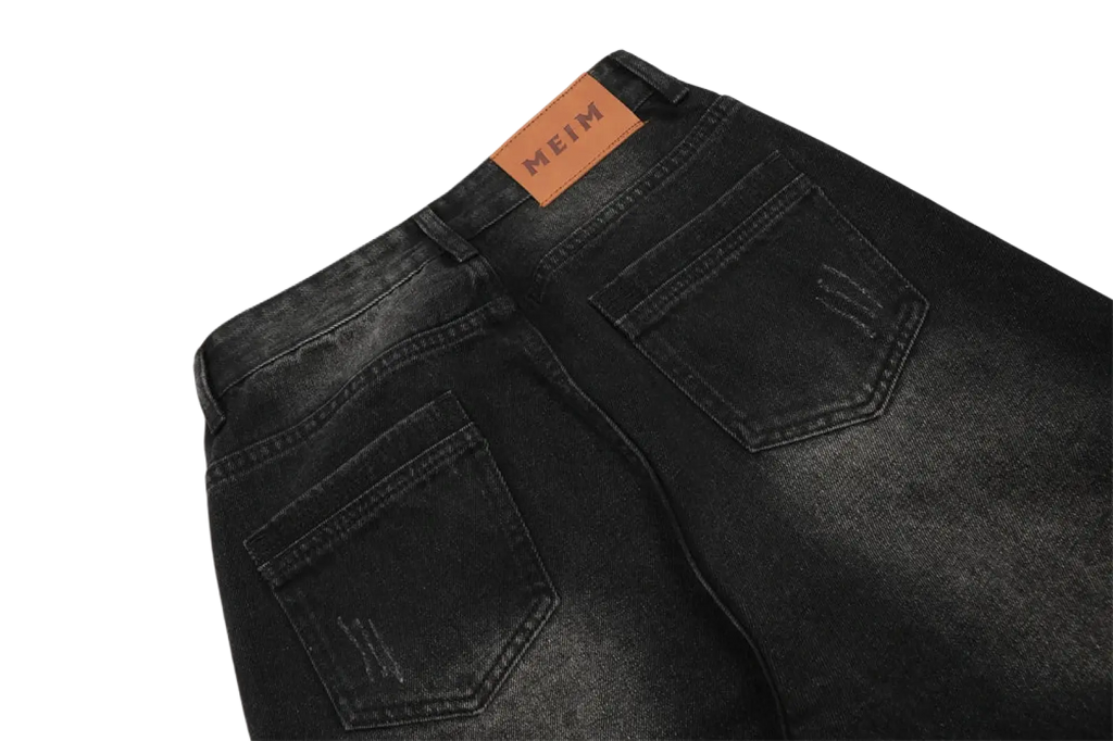 Black denim men’s distressed straight leg jeans with brown leather meim brand tag on the waistband back view