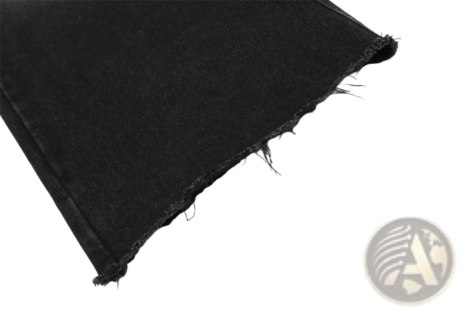 Black denim fabric with a frayed edge from men’s distressed straight leg black denim jeans material close-up