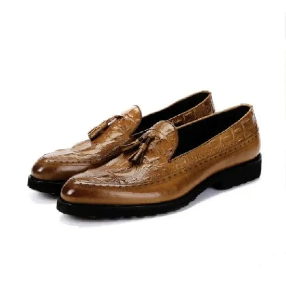 Men’s tan crocodile embossed leather tassel brogue loafers with black rubber soles shown from the back side
