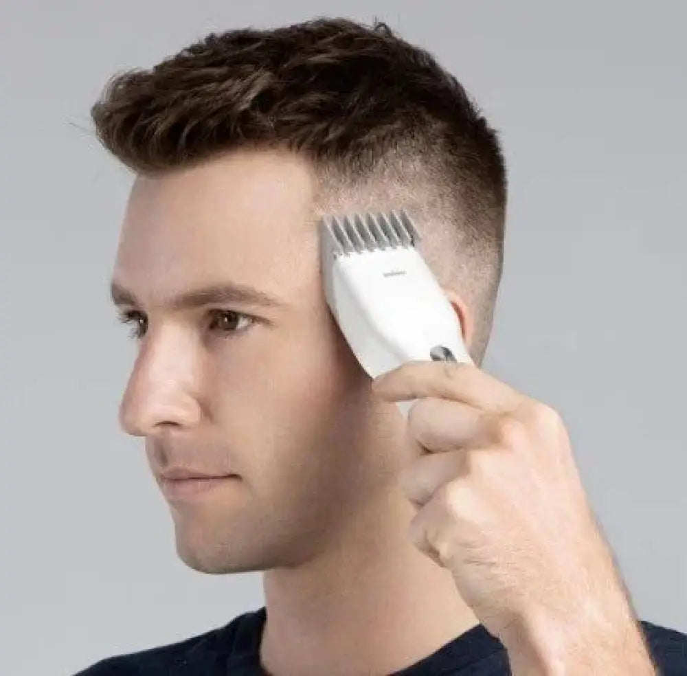 White ergonomic cordless electric hair clipper set with multiple adjustable comb attachments for professional use