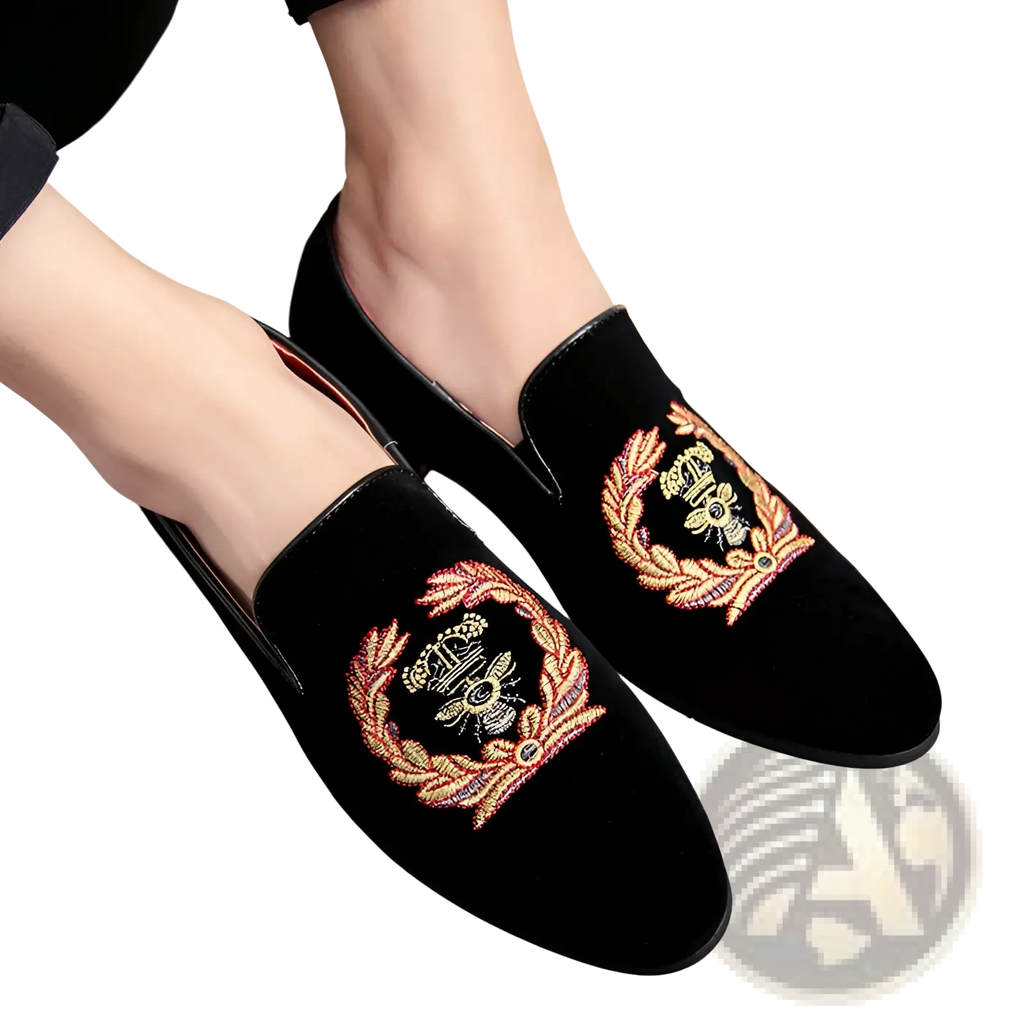 Men’s black velvet slip-on loafers with embroidered laurel wreaths in gold and pink thread around a central bee motif