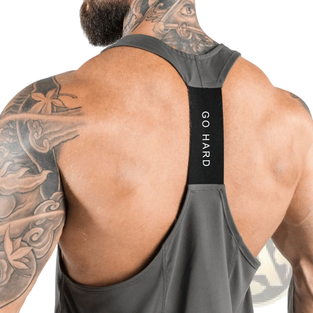 Back view of men’s dark gray go hard racerback athletic tank top with black vertical strap and white text detail