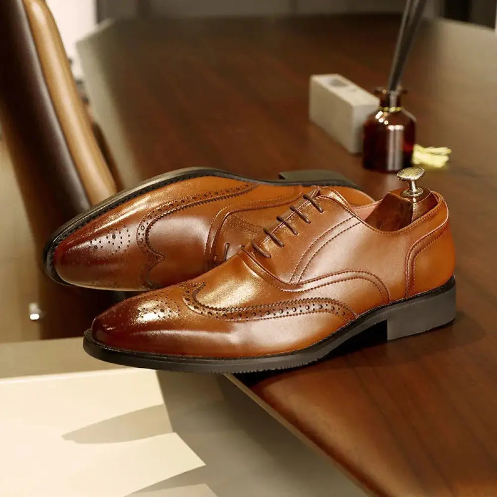 Men’s brown leather brogue oxford shoes with decorative perforations and black rubber soles for dress wear