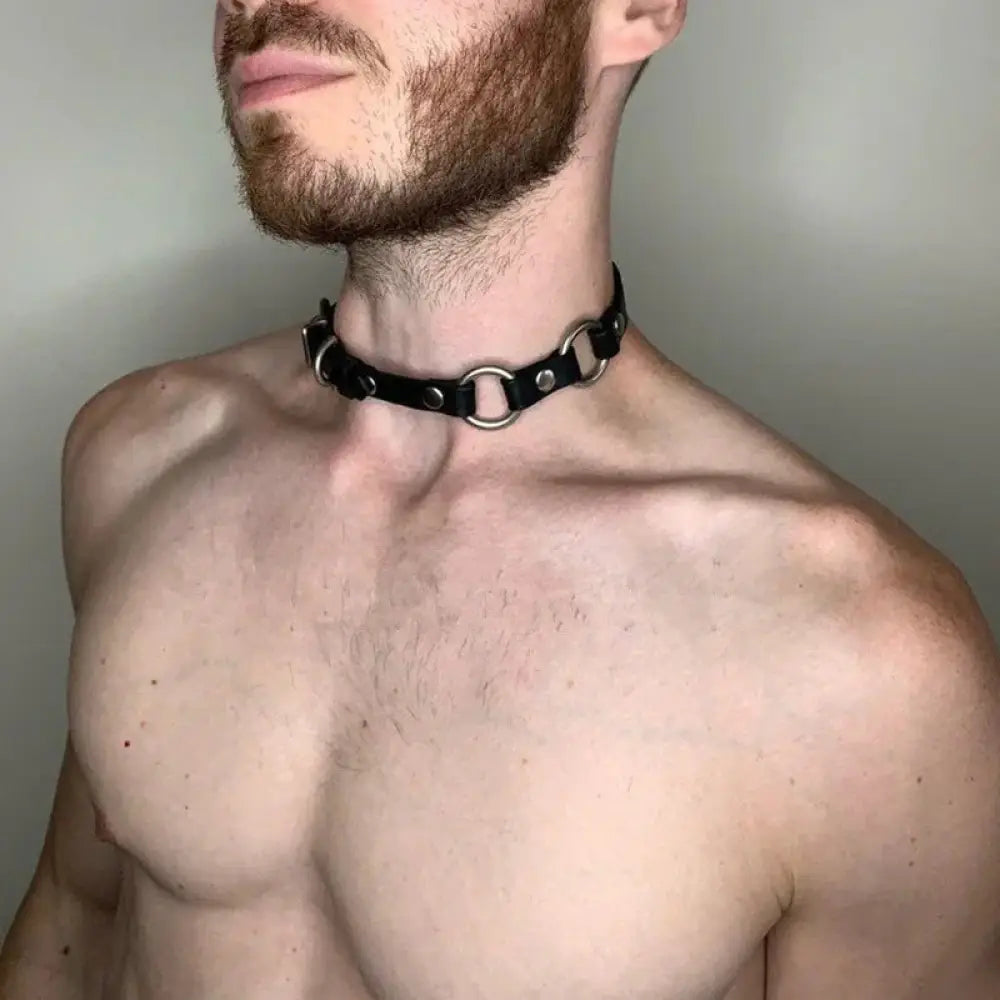 Men’s adjustable black leather shoulder strap with silver studs featuring black leather choker with metal rings and studs