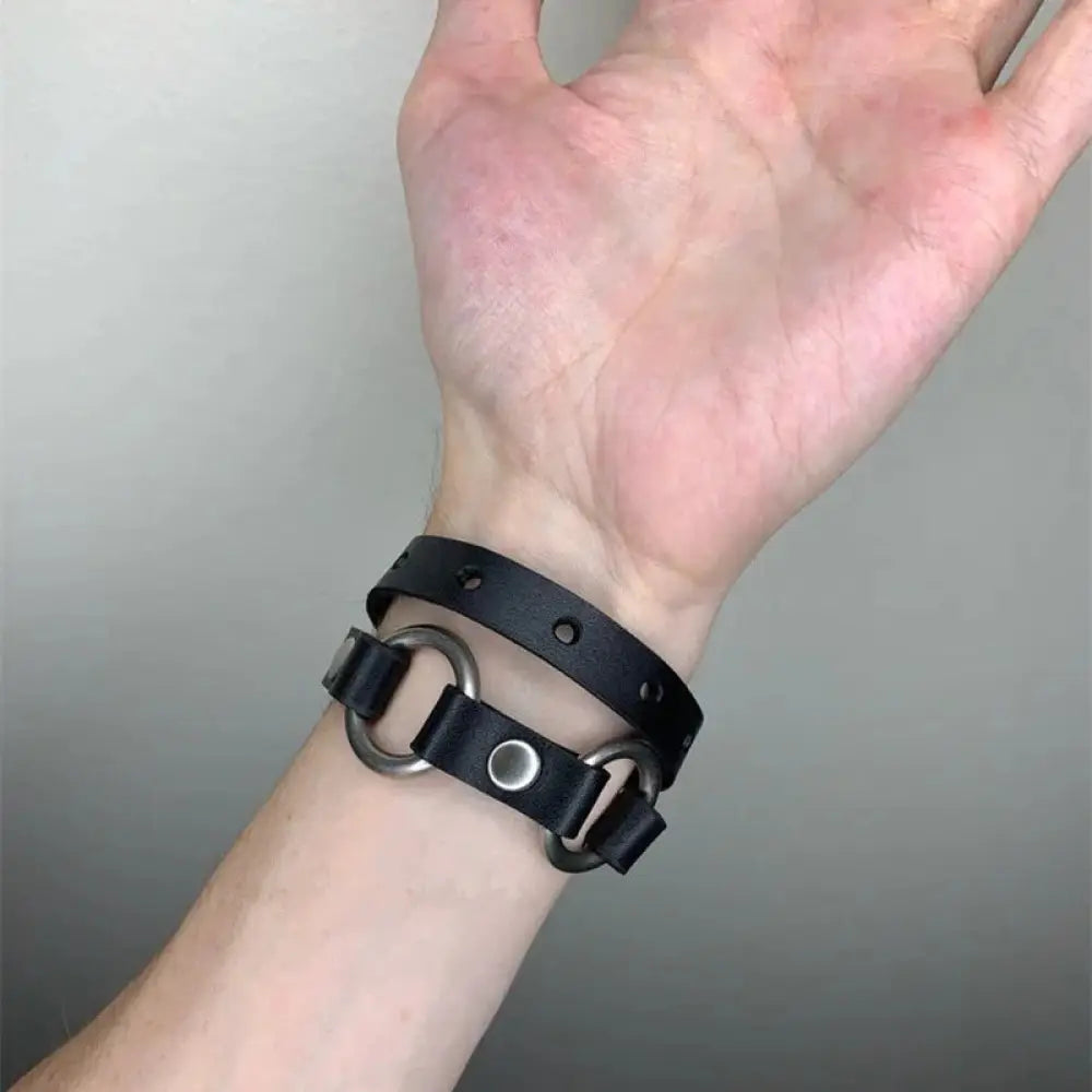 Men’s adjustable black leather shoulder strap with silver studs featuring silver-toned rings and snap closure