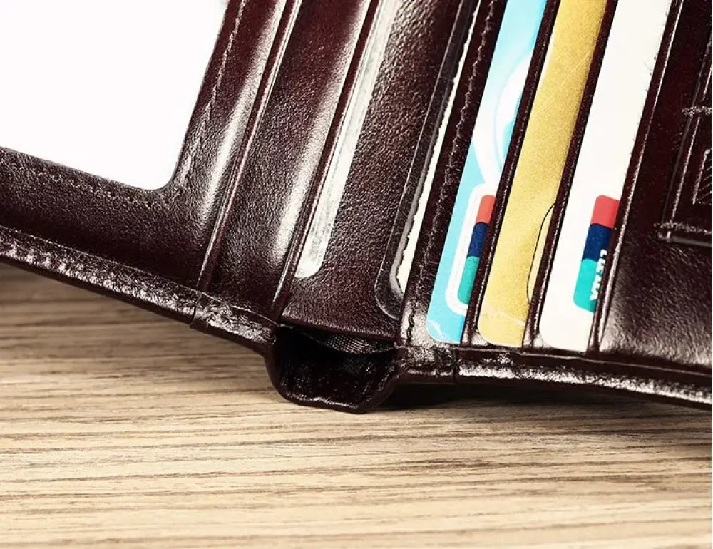 Men’s brown leather tri-fold wallet with id window and multiple card slots holding colorful credit cards