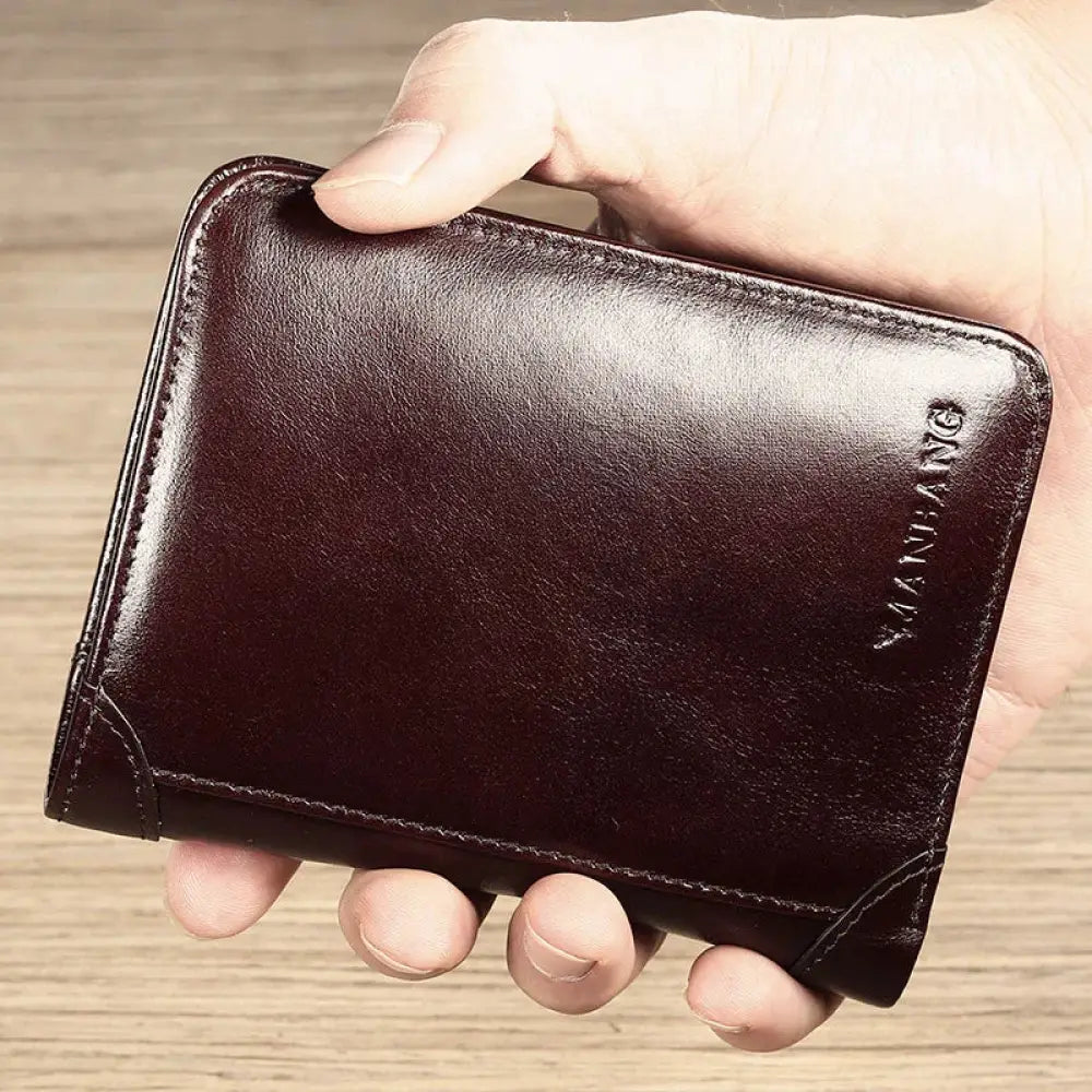 Men’s brown leather tri-fold wallet with id window featuring dark brown leather and subtle embossed brand logo on corner