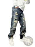 Men’s light blue distressed ripped patch denim jeans featuring multiple ripped patches and frayed edges